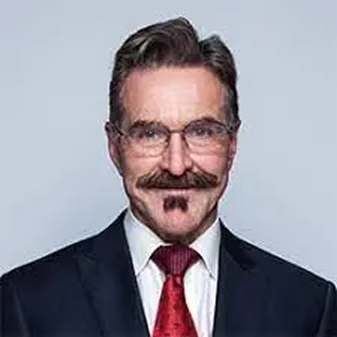 A man with a mustache and glasses in a suit.