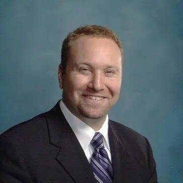 A man in suit and tie smiling for the camera.